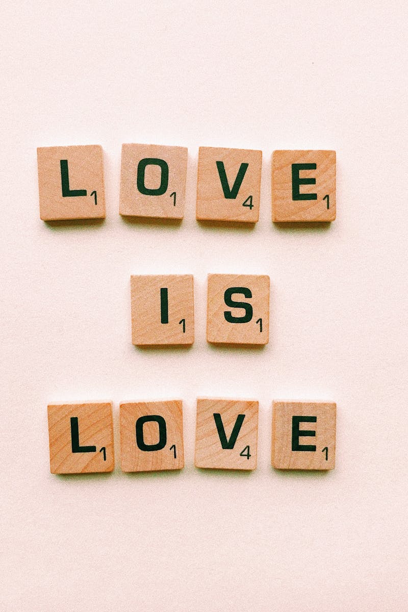 Wooden letter tiles forming 'Love is Love', symbolizing inclusion and pride.